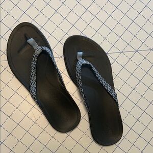 Women’s Olukai Ho’Opio blue strap black footbed.